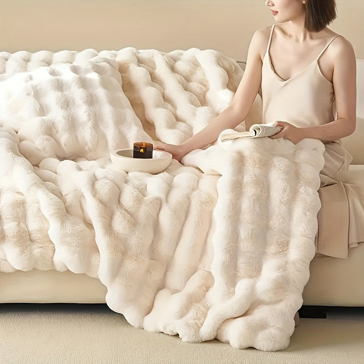 Hyggeligt sofatæppe af blødt faux fur. Skaber varme og komfort i stuen på vinterdage.