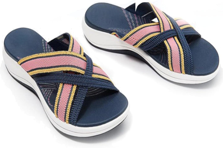 Sideprofil af kvinders sandaler, der fremhæver de krydsede stropper og flade, komfortable sål. Mode og funktion.