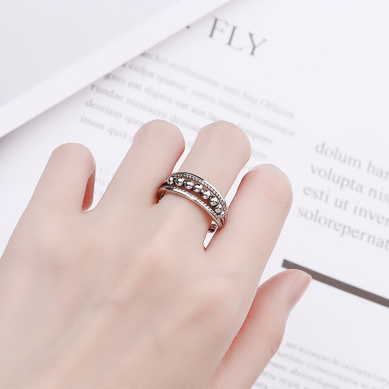 Sølvfarvet unisex snurrende ring i rustfrit stål. Elegant justerbar ring med stressaflastende perler.