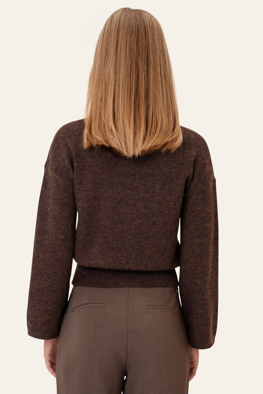 Dame iført blød mørkebrun rundhals sweater. Elegant, langærmet trøje til vintergarderoben, afslappet pasform.