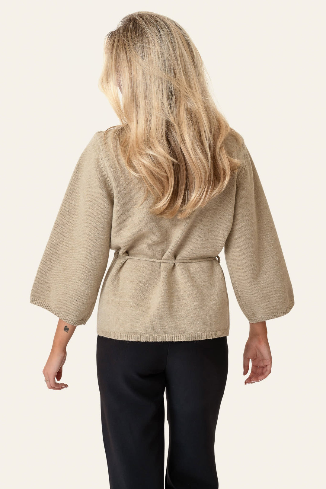 Blød beige kvindecardigan i slå-om design med bindebælte. Elegant overdel til alle outfits.