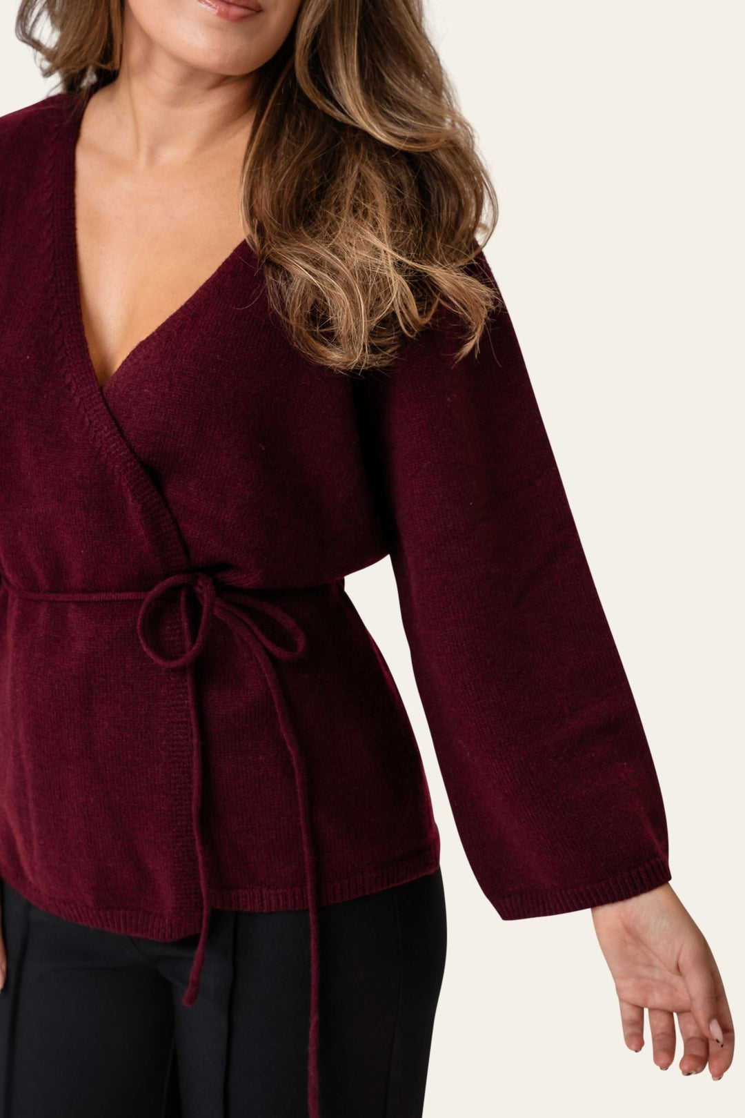 Kvinde cardigan i bordeaux, elegant slå-om stil med bælte. Komfortabel og stilfuld efterårstrøje.
