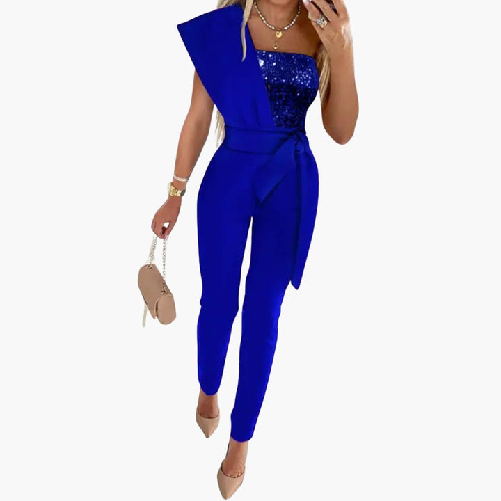 Dame jumpsuit med en skulder, glitrende stof og bindebælte, skaber et chic selskabslook.