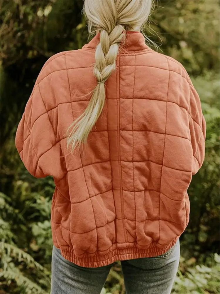 Komfortabel vatteret damejakke med blokmønster, mellemlang og elegant.