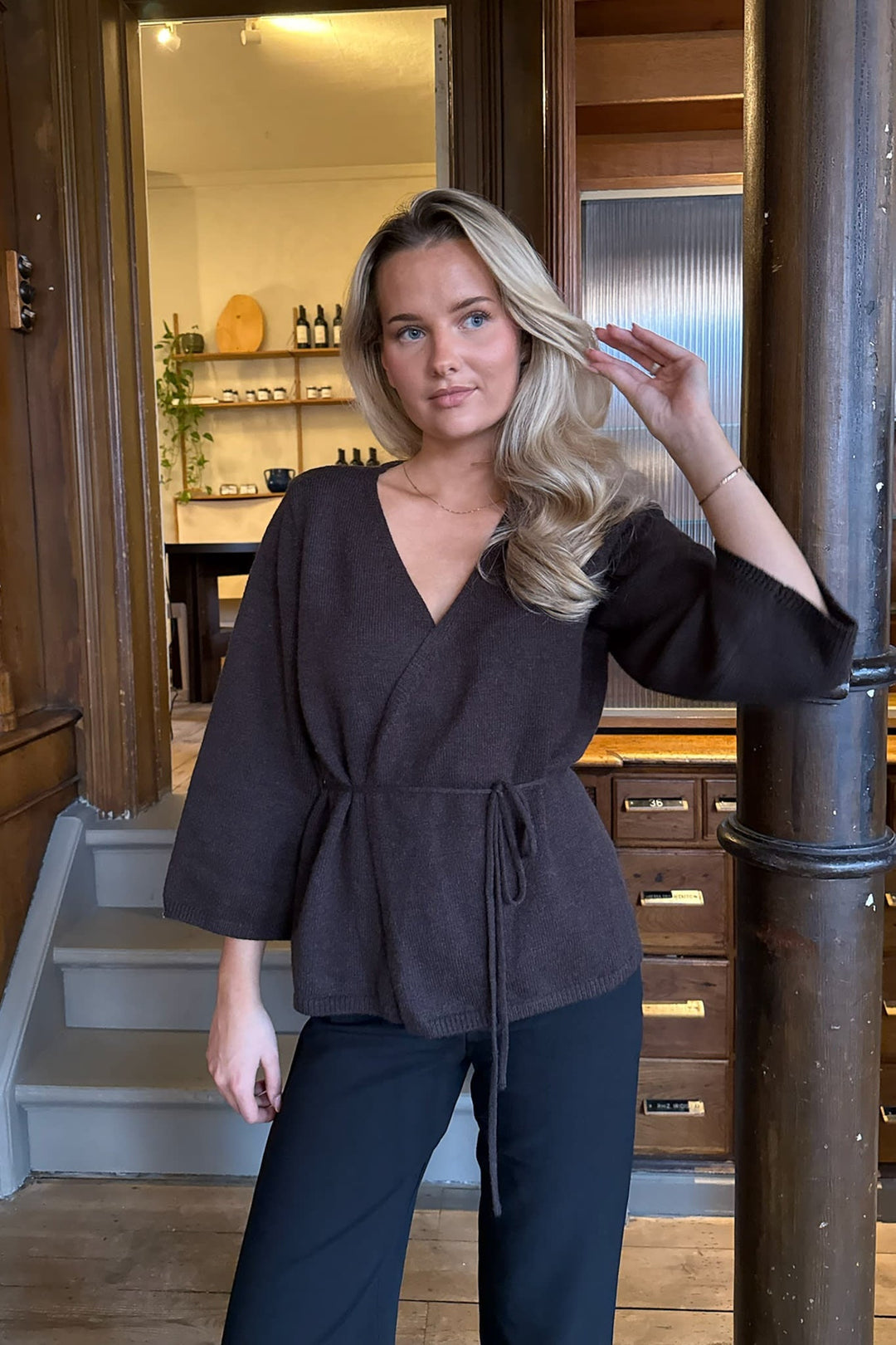 Mørkebrun slå-om damecardigan i elegant design, med taljebælte for en flatterende silhuet.