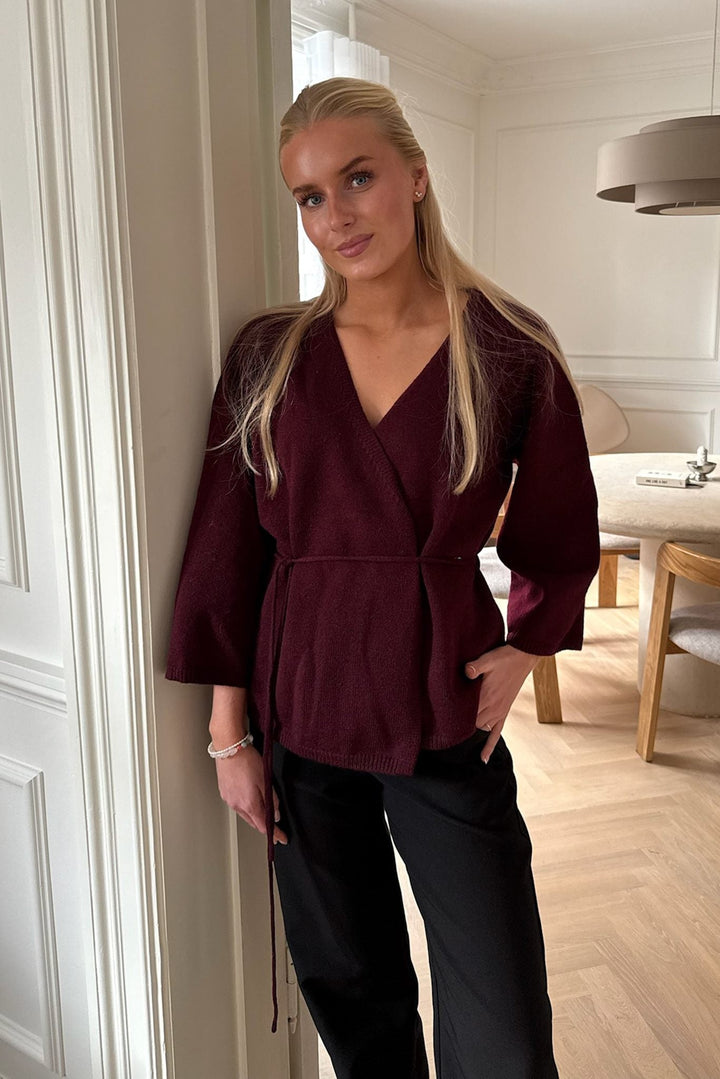 Komfortabel bordeaux slå-om cardigan til kvinder med 3/4 ærmer og bælte. Elegant efterårstrøje.