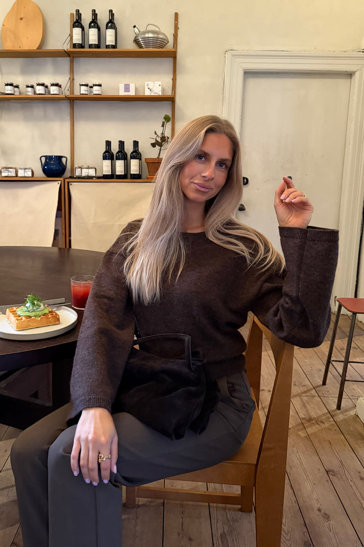 Blød mørkebrun dametrøje i strik, perfekt til hygge. Komfortabel rundhals sweater til efterår og vinter.