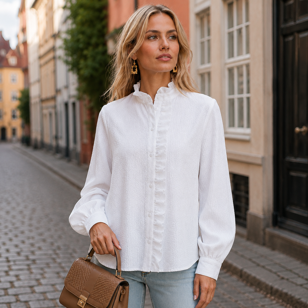 Stilfuld blå kvindebluse med fine flæser og højhalset design. Ideel til et elegant look.