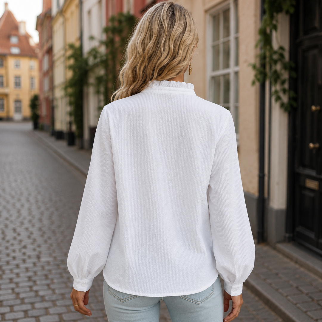 Trendy kvindebluse med diskrete flæsedetaljer, høj hals og komfortabel pasform. En tidløs stil.