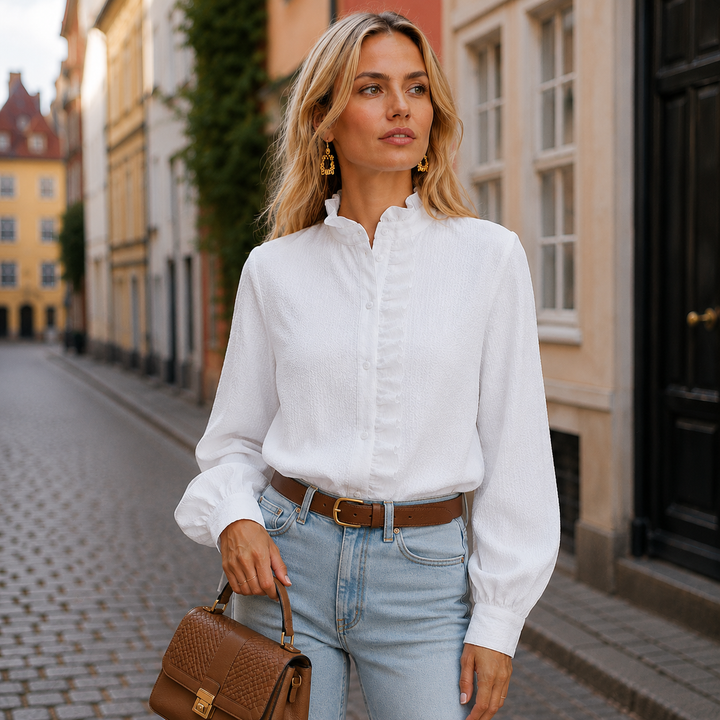 Festlig lyserød kvindebluse med elegante flæser og højhalset krave. Giver et chic og stilfuldt outfit.