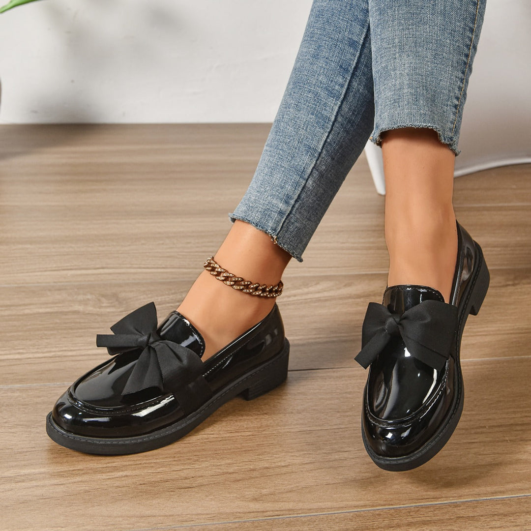 Sorte kvinder loafers med sløjfe på en fod, viser pasform & elegance. Komfortable slip-on sko.
