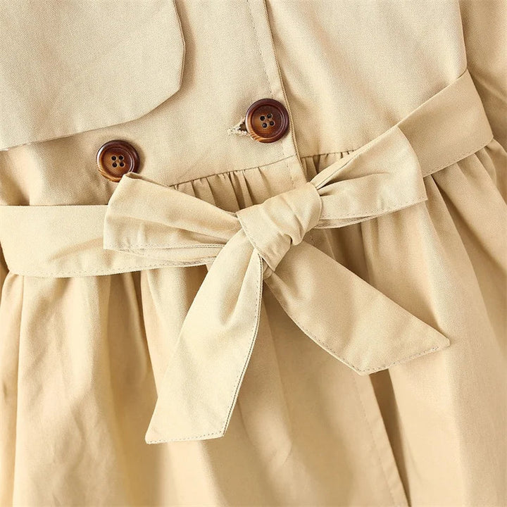Alsidig khaki pige trenchcoat. Elegant vindjakke og forårs-/efterårsjakke for børn med stil.
