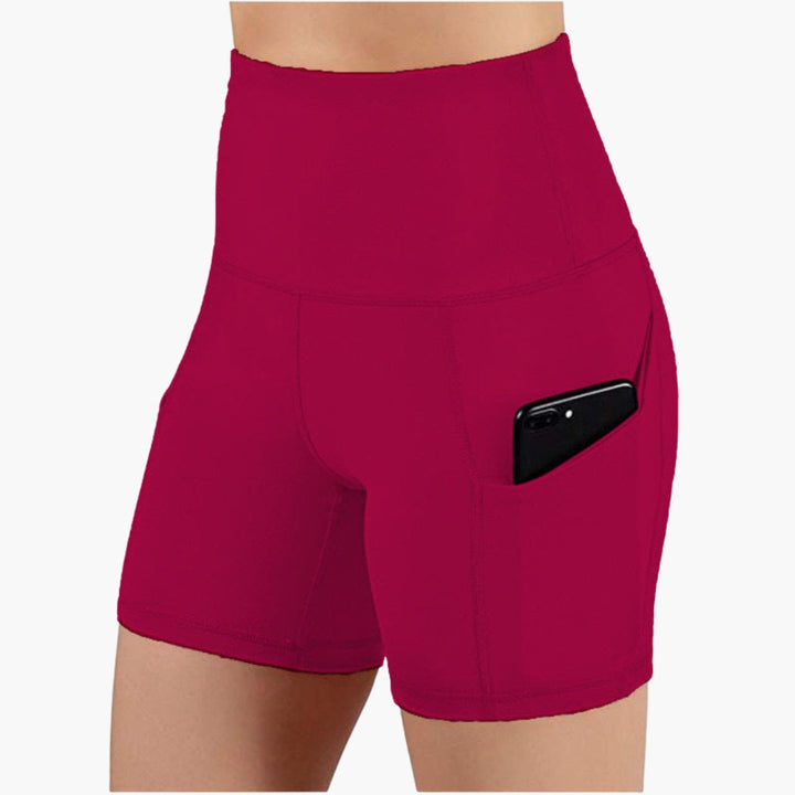 Bløde højtaljede yogashorts til damer med sidelommer, perfekte til stræk og afslappet træning.