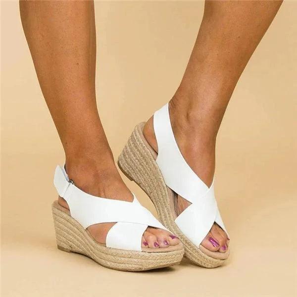 Kvinders stilfulde ortopædiske sommersandaler med espadrille kilehæl og komfortable krydsremme på foden.