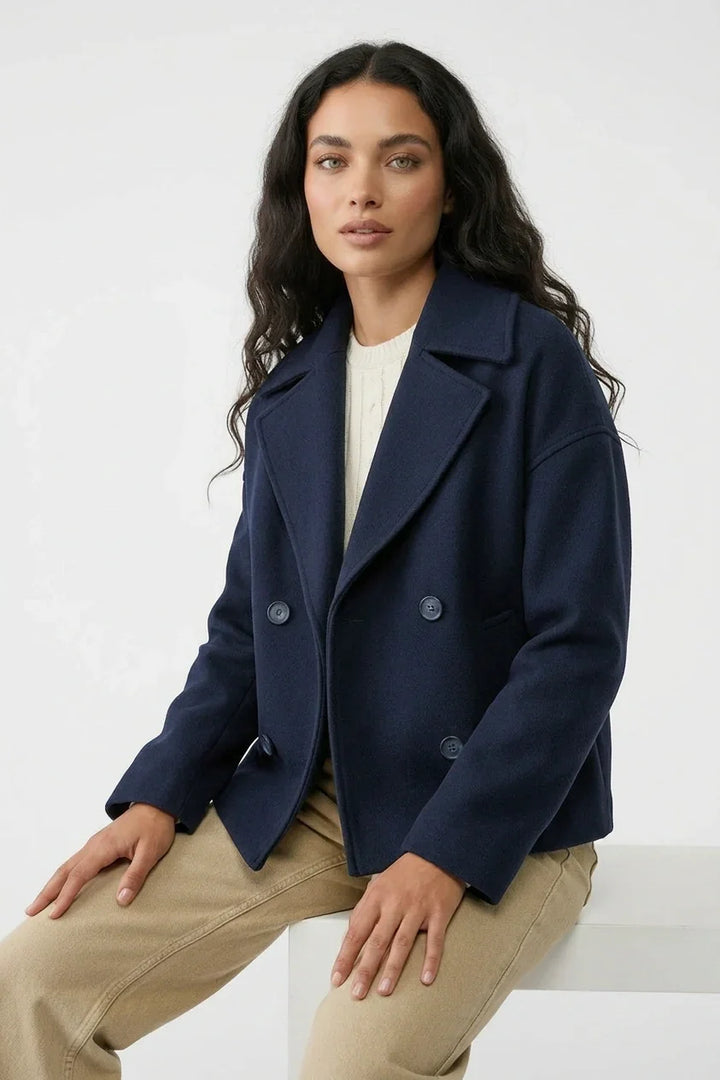 Kort damejakke med elegant dobbeltknaplukning. Cropped design og stilfuld pasform til alle anledninger.