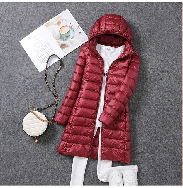Elegant lang dunjakke til kvinder med aftagelig hætte, perfekt til vinter. Vindtæt og vandtæt kvindejakke.