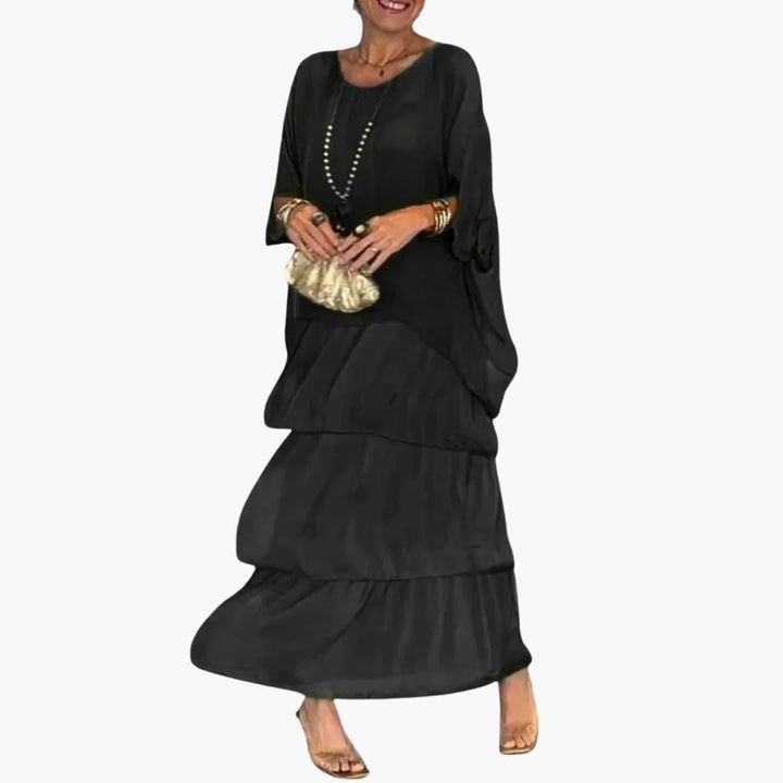 Flot lang kvindekjole, maxi model, i elegant A-line design med smock ærmer. Rund hals og behagelig pasform til sommer.