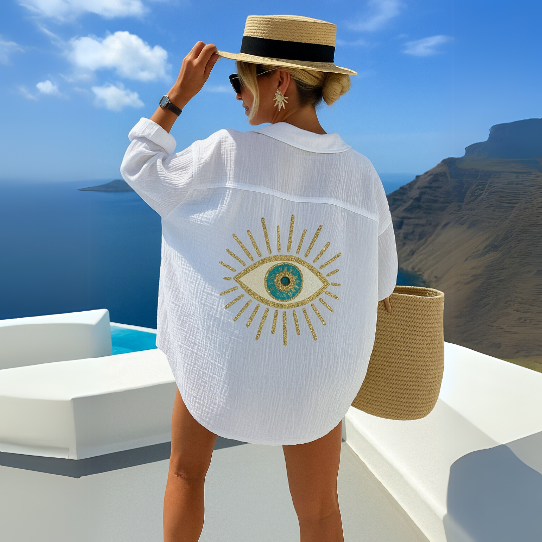 Stilfuld oversize kvindebluse med delikate broderier og diskrete pailletter; ideel til sommerdage.