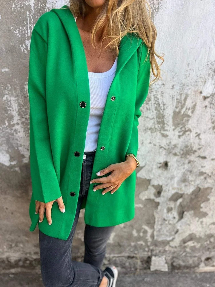 Kvinde i Anya hættekardigan med knapper, perfekt til lag-på-lag styling.
