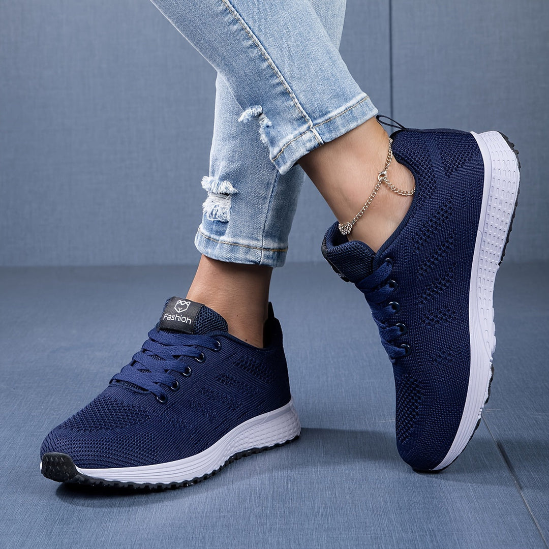 Sporty damesneakers velegnet til forskellige aktiviteter, udstyret med åndbar mesh og snørebåndsdesign.