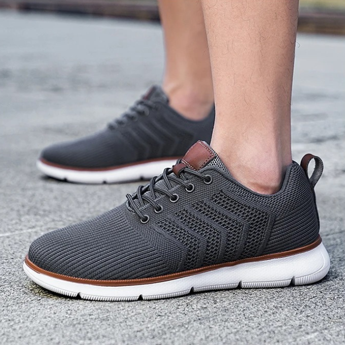 Detaljebillede af grå åndbar herrer sneaker, med fokus på tekstur og snøredetaljer, ideel til aktiv livsstil.