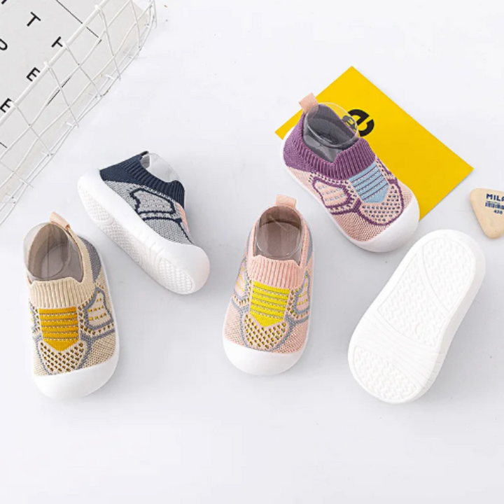 Babysko i åndbart materiale med fleksibel sål og stilfuldt design i søde farver, ideelle til småbørn.