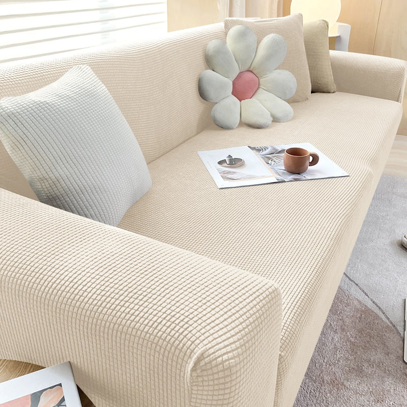 Beige sofabetræk i elastisk strækstof, perfekt pasform, beskyttelse mod pletter, snavs og dyrehår.