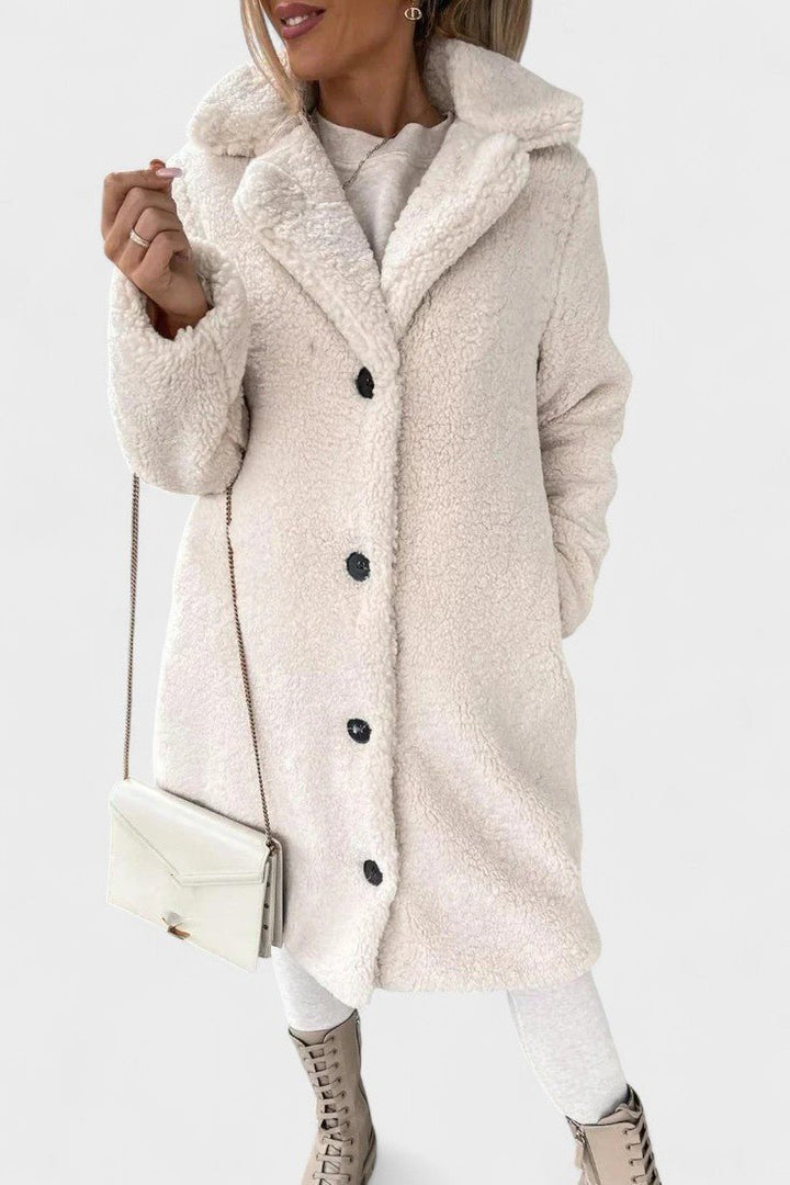 Dame i varm brun/beige teddyjakke udendørs. Blød, komfortabel efterårsjakke; elegant overtøj.