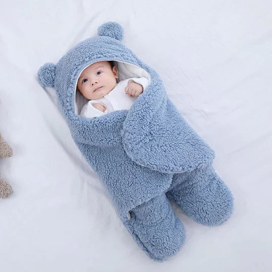 En baby trygt svøbt i et blødt og varmt svøbetæppe. Sikrer god søvn og komfort for spædbørn.