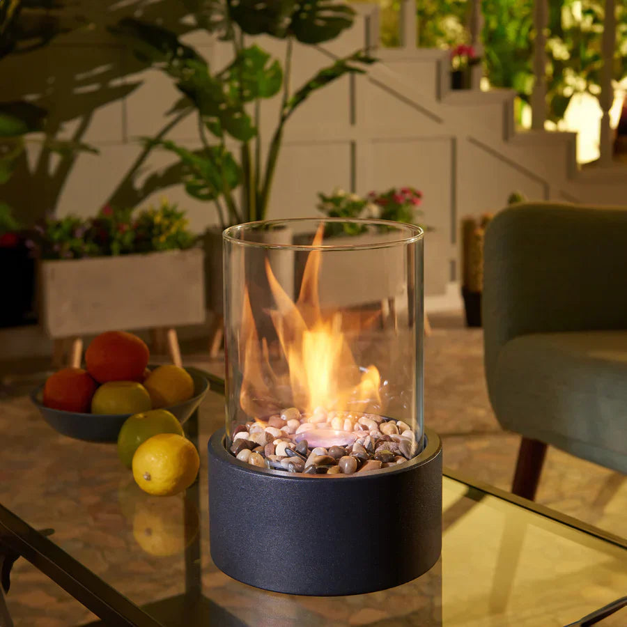 Elegant glas biopejs med sort base, røgfri og nem at placere på borde inde og ude.