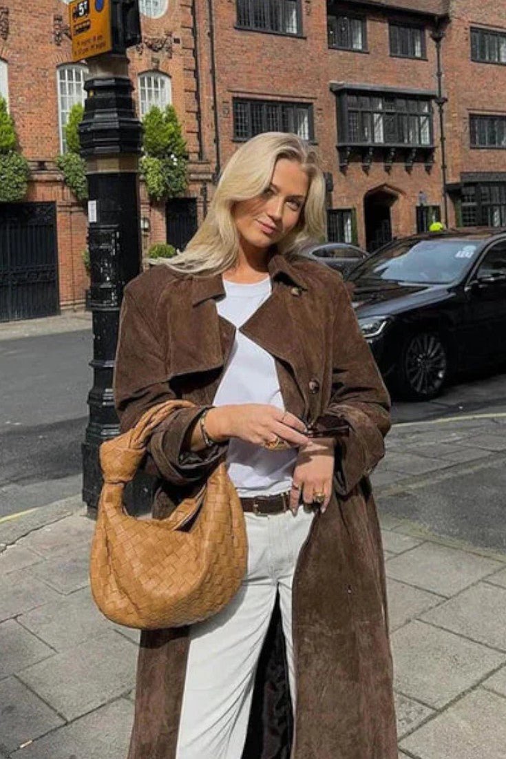 Kvinders brun trenchcoat i klassisk, elegant stil, vist på model. Feminin og alsidig figursyet jakke.