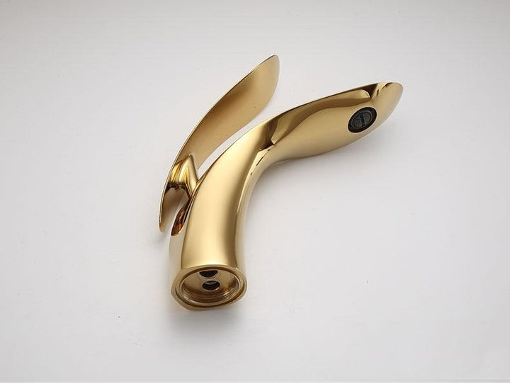 Luksus guld håndvask armatur i buet design. Moderne vandhane til et stilfuldt badeværelse.