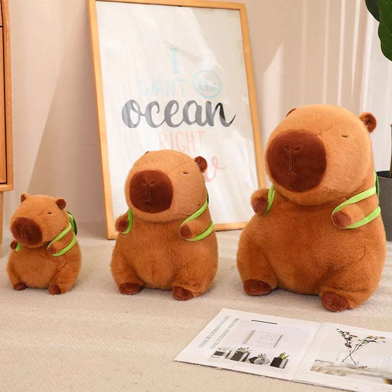 Capybara plysdyr set fra siden, med grøn skildpadde rygsæk, brun, med sødt ansigtsudtryk, perfekt til børneværelset.