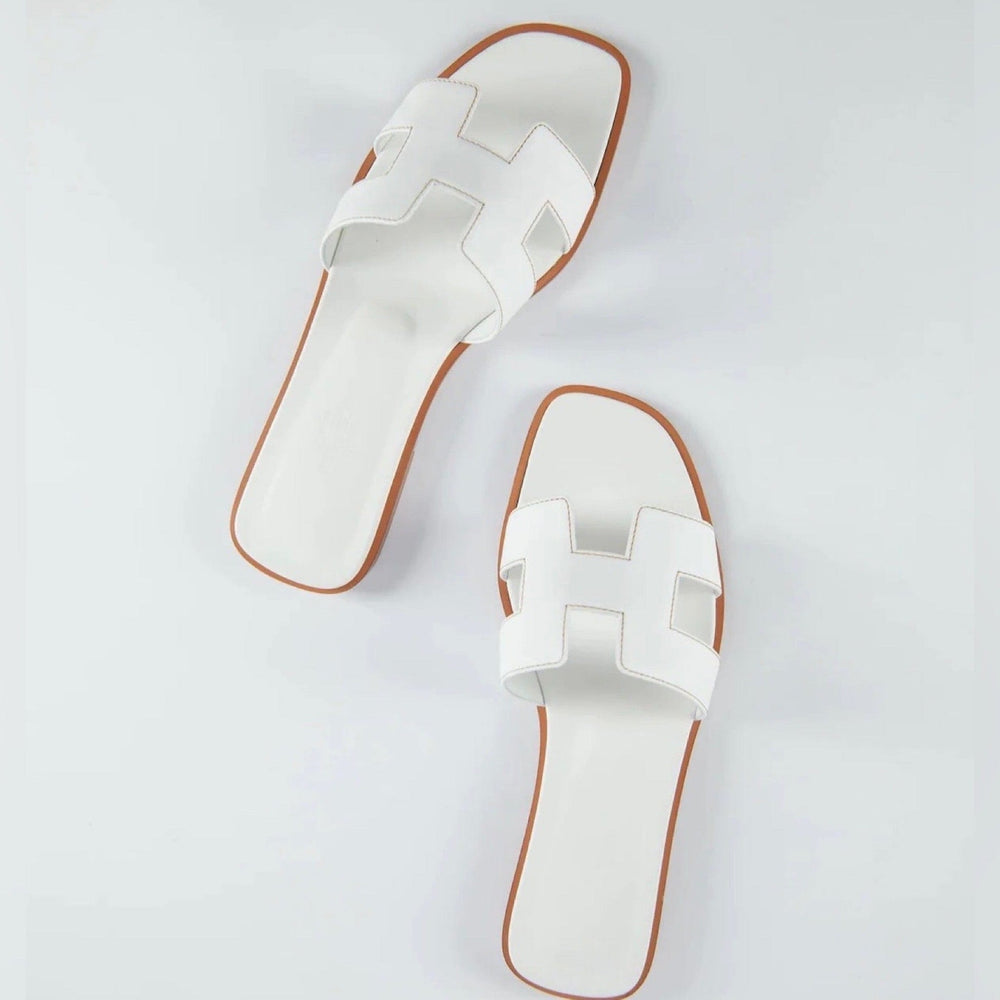 Tidløse flade sandaler til damer i klassisk design, ideelle til elegant sommerlook.