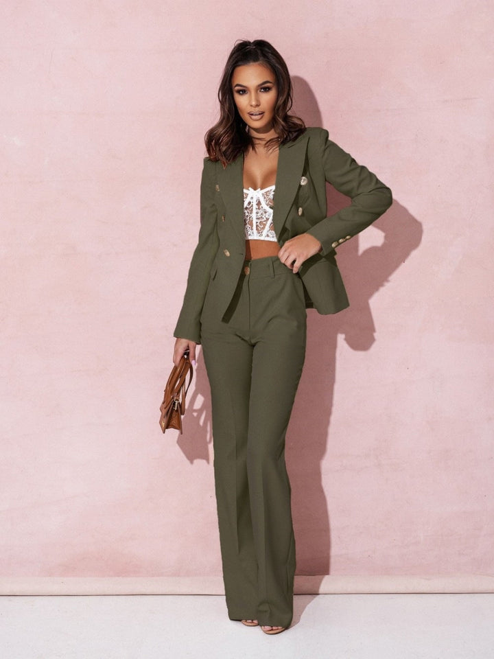 Model iført et elegant dame jakkesæt med dobbeltradet blazer og matchende bukser, ideelt til business mode.