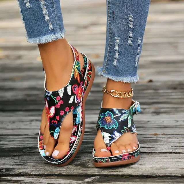 Dame ortopædisk sandal med kilehæl. Sort/hvid blomstret design giver sommerkomfort og stil.