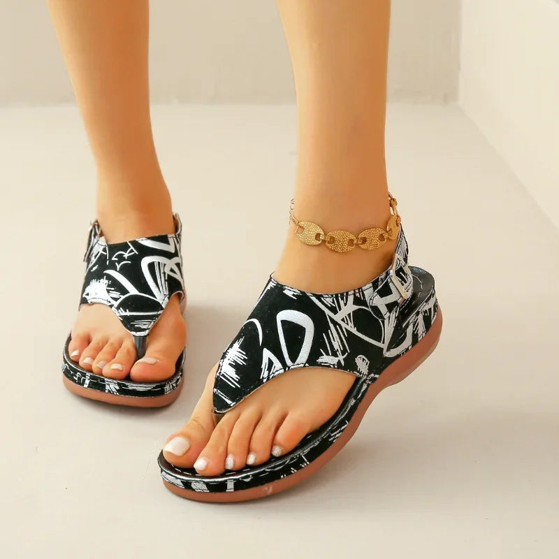 Komfortabel og modebevidst dame ortopædisk sandal. Sort/hvid blomstret kilehæl for sommerens stilfulde skridt.