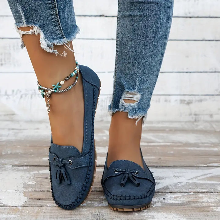 Sidevisning af sorte ortopædiske loafers, viser tyk sål og støtte til foden, elegant fodtøj.