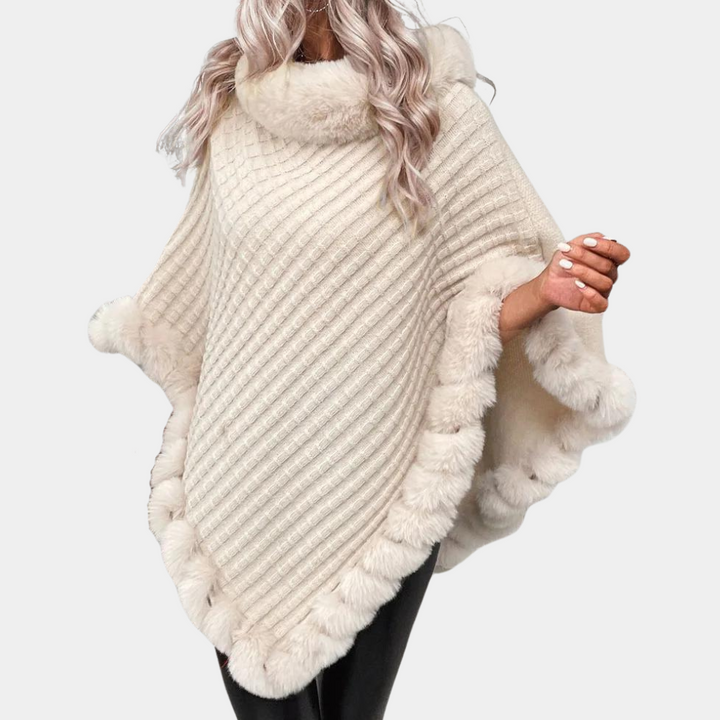Dame strikket poncho-trøje i abrikos, elegant og varm. Perfekt til efterår og vinter.