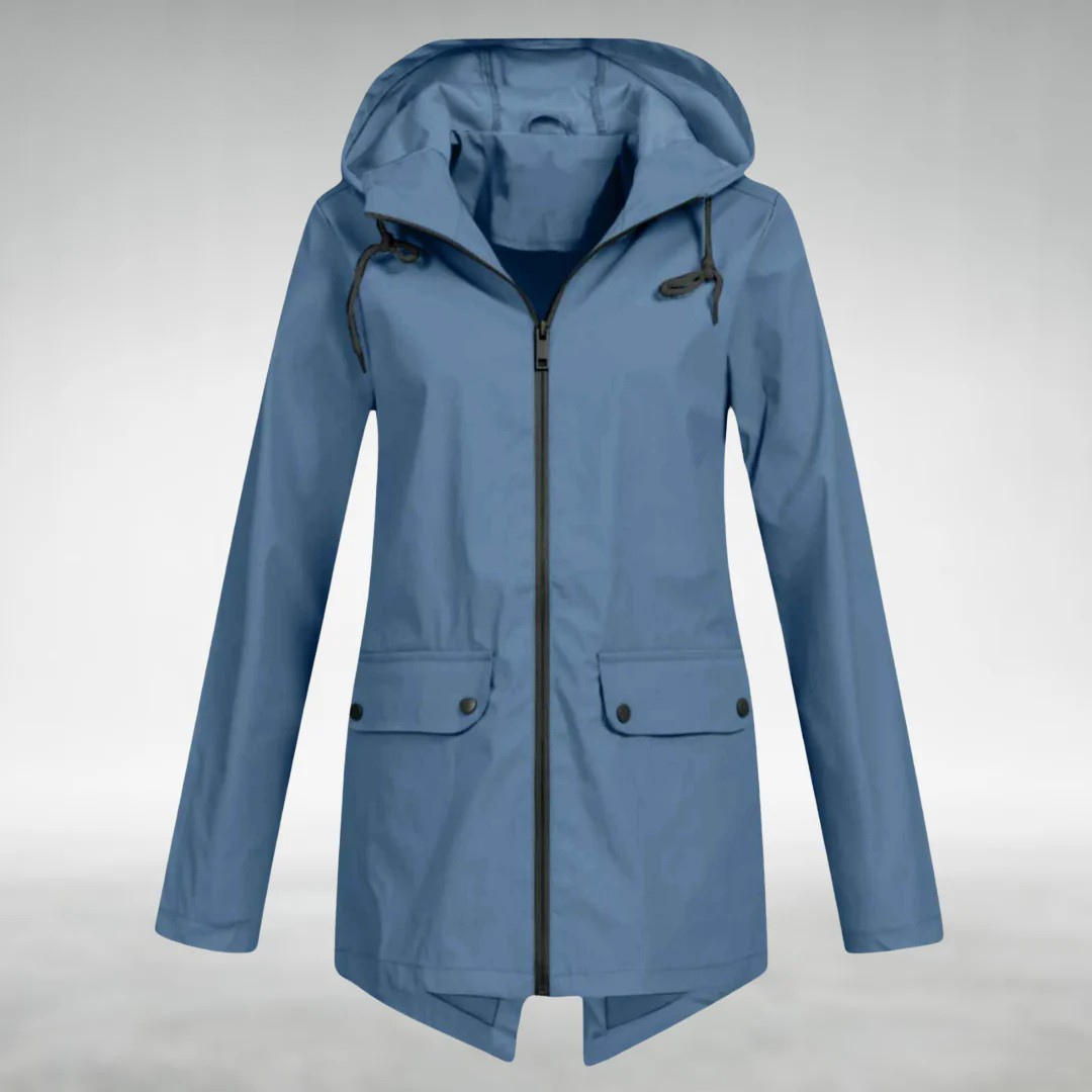 Kvinde iført vindtæt softshell hættejakke, klar til vandretur. Komfortabel og figursyet.