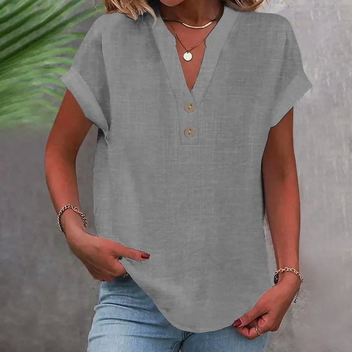 Feminine damebluse med elegant V-udskæring og dekorative knapper. Komfortabel løs pasform til hverdag.