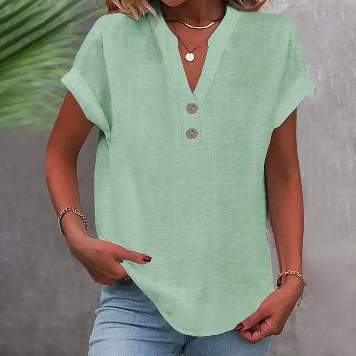 Løs damebluse med V-udskæring og knapper. Kortærmet sommerbluse i afslappet stil for kvinder.