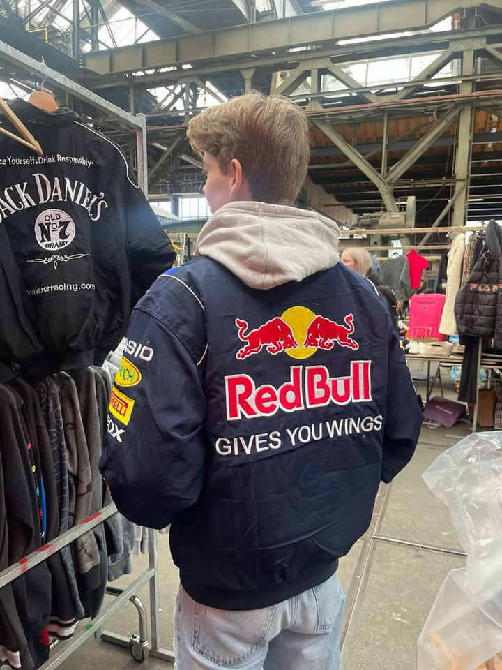 Red Bull damejakke i et elegant og sporty design, vejrbestandig, fås i størrelserne S-XL, vist forfra.