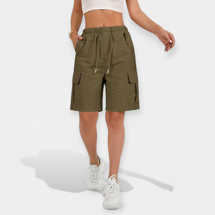 Model iført stilfulde dames cargo shorts, der fremhæver den afslappede pasform og de praktiske lommer.