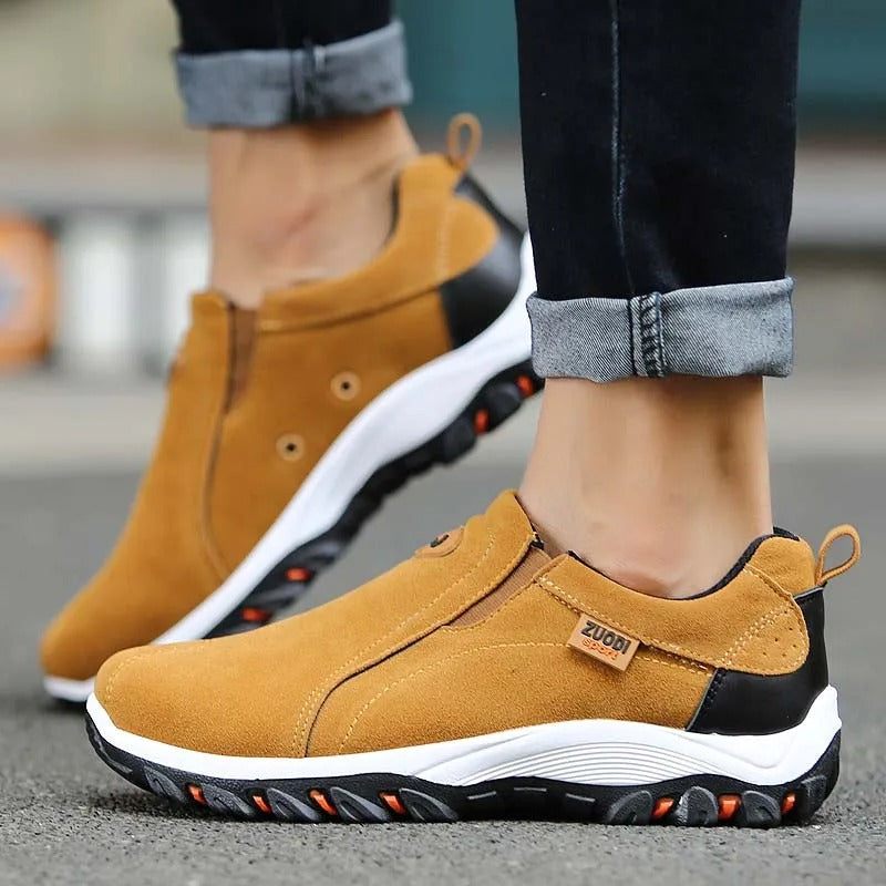 Nærbillede af tekstur på sorte slip-on herresko. Åndbart materiale for optimal komfort.