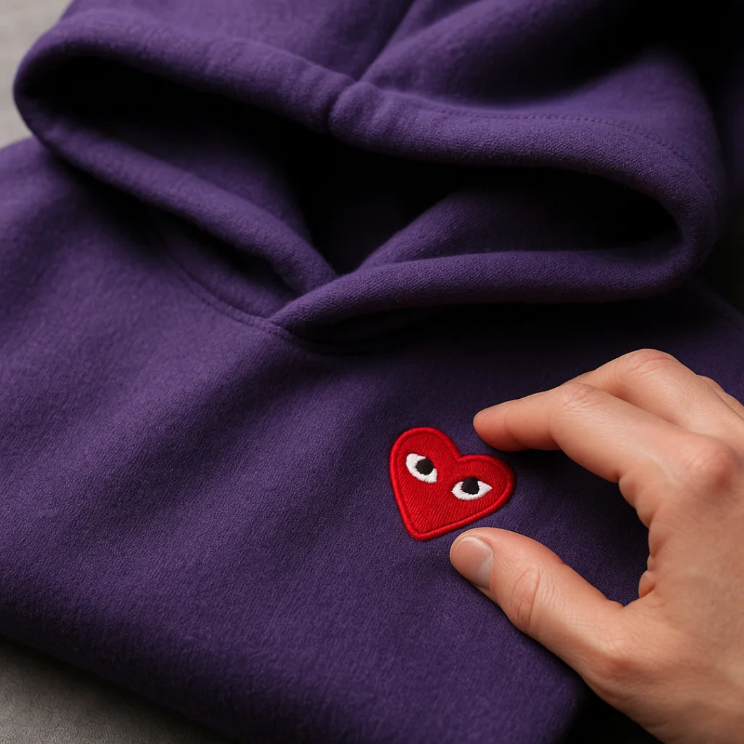 Model i kvinders hjertesweater og jeans, et eksempel på casual og stilfuld hverdagskomfort.