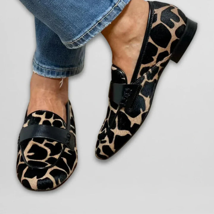 Moderigtige, mønstrede loafers til kvinder i sort og hvidt ko-print. Ideelle som hverdags-slip-on sko.