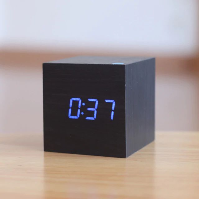 Digital bordur i moderne, minimalistisk terningdesign af træ, ideel til skrivebord eller hylde, med kompakt størrelse.