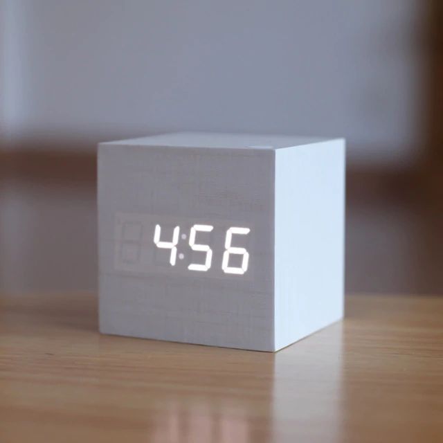 Digital bordur i moderne, minimalistisk terningdesign af træ, ideel til skrivebord eller hylde, med kompakt størrelse.
