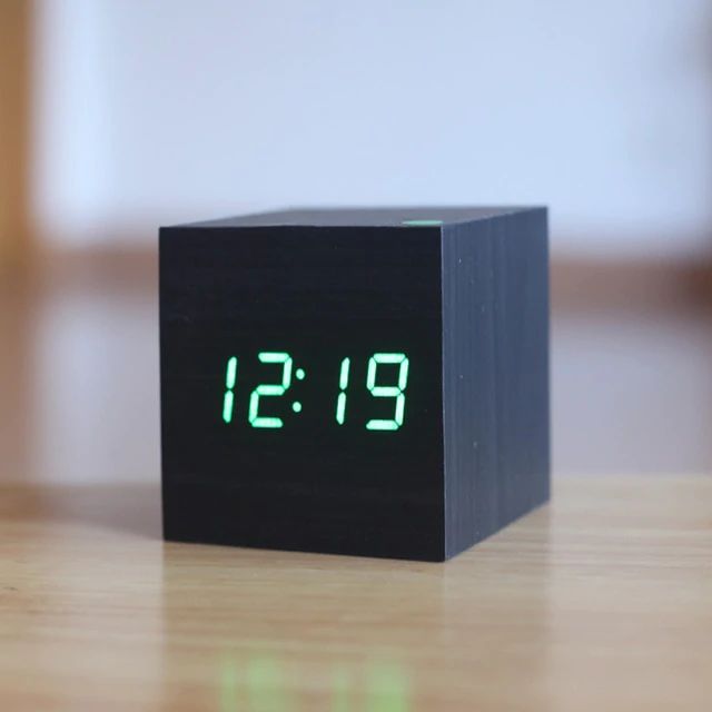 Digital bordur i moderne, minimalistisk terningdesign af træ, ideel til skrivebord eller hylde, med kompakt størrelse.